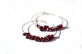 Hoop earrings with violet garnet gemstone, jewelry. Royalty Free Stock Photo