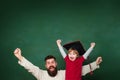 Hooray. Father teaching her son in classroom at school. Two generations. Young boy doing his school homework with his Royalty Free Stock Photo