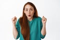 Hooray winner. Smiling lucky redhead girl, watching a game, celebrating victory, looking up and rooting for team