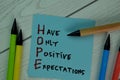 HOPE - Have Only Positive Expectations write on sticky notes isolated on Wooden Table