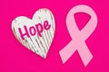 Hope message on weathered heart with pink cancer ribbon on bright pink