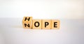 Hope or nope symbol. Male hand turns cubes and changes the word `nope` to `hope` on a beautiful white background. Business and