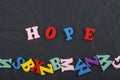 HOPE word on black board background composed from colorful abc alphabet block wooden letters, copy space for ad text. Learning Royalty Free Stock Photo