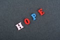 HOPE word on black board background composed from colorful abc alphabet block wooden letters, copy space for ad text Royalty Free Stock Photo