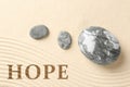 Hope. Zen garden stones on sand with pattern, top view Royalty Free Stock Photo