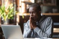 Hopeful black guy hope for best reading news on laptop