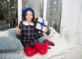 Hopeful concept. Kid at home relaxing on cozy window sill. Magic moment. Happy winter holidays. Small girl opening gift Royalty Free Stock Photo