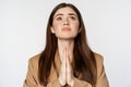 Hopeful corporate woman, student praying, begging god, looking up and pleading, standing over white background Royalty Free Stock Photo