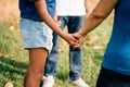 Hopeful family of father and teenage daughter, and mother holding hands together in circle and praying in outdoor park Royalty Free Stock Photo