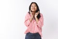 Hopeful and optimistic cute excited young asian woman in striped blouse close eyes and smiling broadly cross fingers for