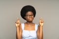 Worried african woman crossing fingers, afro female student praying while waiting for exam result Royalty Free Stock Photo