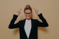 Hopeful young woman standing with hands up and crossed fingers in luck gesture Royalty Free Stock Photo