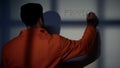 Hopeless male prisoner writing word freedom on wall, asking for amnesty, help