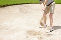 Hoping this shot was enough...Senior man trying to hit his ball out of the sandtrap on the golf course. Royalty Free Stock Photo