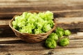Hops in basket on brown wooden background Royalty Free Stock Photo