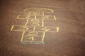 Hopscotch game being drawn with a chalk on the asphalt. Popular street game