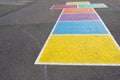 Hopscotch painted on the ground in various colors with weekdays in German language in a schoolyard in Switzerland