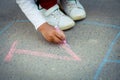 Hopscotch in a schoolyard on an asphalt floor with chalk drawings of numbers and squares as an icon of youth innocence