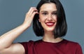 Horiozntal studio candid portrait of a young woman with red lips smiling broadly with white teeth. Brunette female model with red Royalty Free Stock Photo