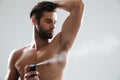 Horizntal image of young man using deodorant Royalty Free Stock Photo