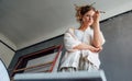 Horizonal shot of an artist female standing next to the easel with canvas painting something in her art studio Royalty Free Stock Photo