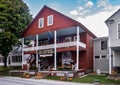 Horizontal autumnal view of tourists outside the historic family owned red wooden Vermont Country