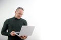 Horizontal banner of a beautiful smiling business man holding a laptop in his hands, typing and browsing the web Royalty Free Stock Photo