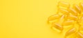 Horizontal banner with close up Omega 3 capsules on yellow background. Fish oil softgels. Copy space for your text