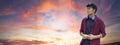 Horizontal banner or header with  young asiatic man using mobile smart phone against a  dramatic sunset sky - Generation z Royalty Free Stock Photo