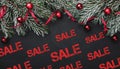 Horizontal black stone background with fir branches decorated with red balls. Top view. With sale text Royalty Free Stock Photo