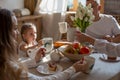Horizontal close-up photo of a family of four who enjoy breakfast together Royalty Free Stock Photo