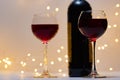 Horizontal close-up photo of two glasses of red wine and part of a bottle of wine. Royalty Free Stock Photo