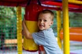 Horizontal closeup portrait of a funny seven year old boy playing on the playground