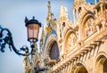 Horizontal closeup of top part of facade of Basilica and Cathedral of San Marco in Venice, Italy, with vintage lamp. Travel Royalty Free Stock Photo