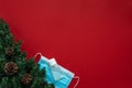 Christmas decoration with Coronavirus on a red background, face mask and hydroalcoholic gel. Covid concept on christmas Royalty Free Stock Photo