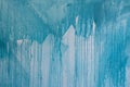 Horizontal color pattern texture photograph of turquoise blue paint dripping down a white wall. Creative background, abstract