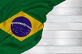 Horizontal colored national flag of modern state of Brazil, beautiful silk, white wood background, concept of tourism, economy,