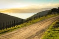 Metalled rural road with baton and wire fence, Mahia Peninsula, North Island, New Zealand Royalty Free Stock Photo