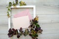Horizontal composition with flatlay with square white wooden frame and mockup and copyspace pastel pink envelopes
