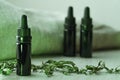 Horizontal composition of three 10 ml black glass bottles surrounded with dried herbs
