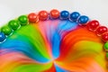 Horizontal dome of skittles rainbow candy as sugar and water mix into a psychedelic hippie flower on a white background