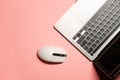 Horizontal flat lay minimalist photo with a silver grey laptop computer, and a wireless white-colored mouse on a pink background Royalty Free Stock Photo