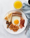 Irish classic breakfast. Fried eggs, grilled sausages, mushrooms, bacon, beans, coffee, orange juice Royalty Free Stock Photo