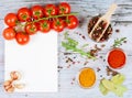 Horizontal food banner with cherry tomatoes, garlic, peppercorns, spice and notebook on wooden background. Empty space for text.