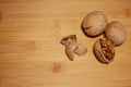 The horizontal frame. Three walnuts are lying on a bamboo Board, one is split and there is a shell next to it