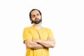 Horizontal image of bearded man, hair in a ponytail and crossed arms looking upwards pensively isolated on white background. He is Royalty Free Stock Photo