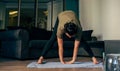 Horizontal image of fit young woman exercising at home, stretching legs in the room doing pilates workout.. Female warming-up Royalty Free Stock Photo