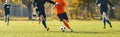 Horizontal image of football players running in a duel on a tournament match. Soccer forward player compete with defender Royalty Free Stock Photo
