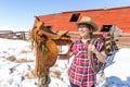 Happy cowgirl standing next to her saddle holding a rope. Royalty Free Stock Photo