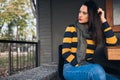 Horizontal image of hipster girl sitting outdoors at cafeteria while waiting friends. Happy young woman sitting outdoors in the Royalty Free Stock Photo